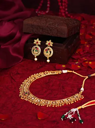 Gold jewellery styled on red silk